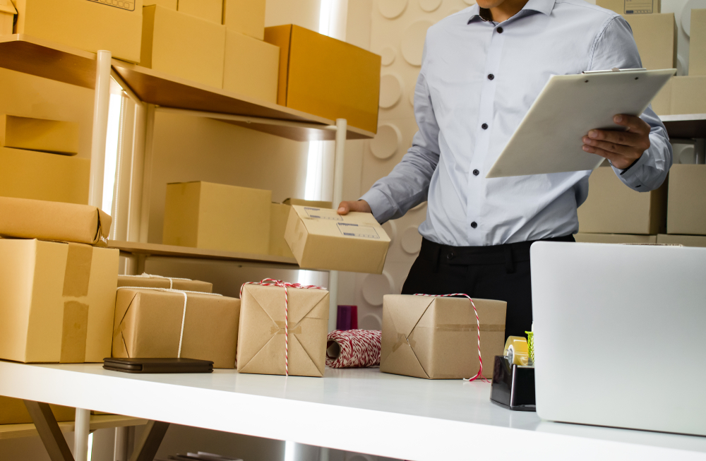 Фото мужчина упаковывает товар в коробки для продажи