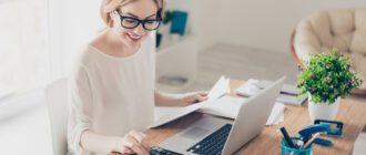 Фото девушка в очках делает расчеты на калькуляторе